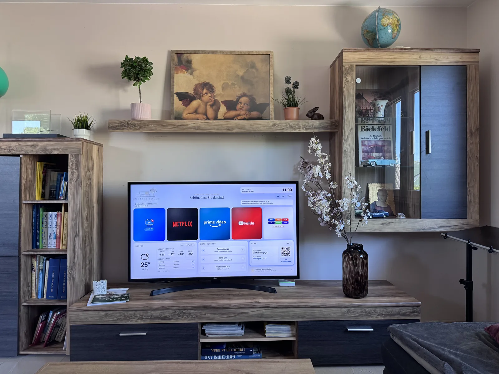 Wohnwand mit 55-Zoll-TV und Regalen im Deluxe Apartment Eins