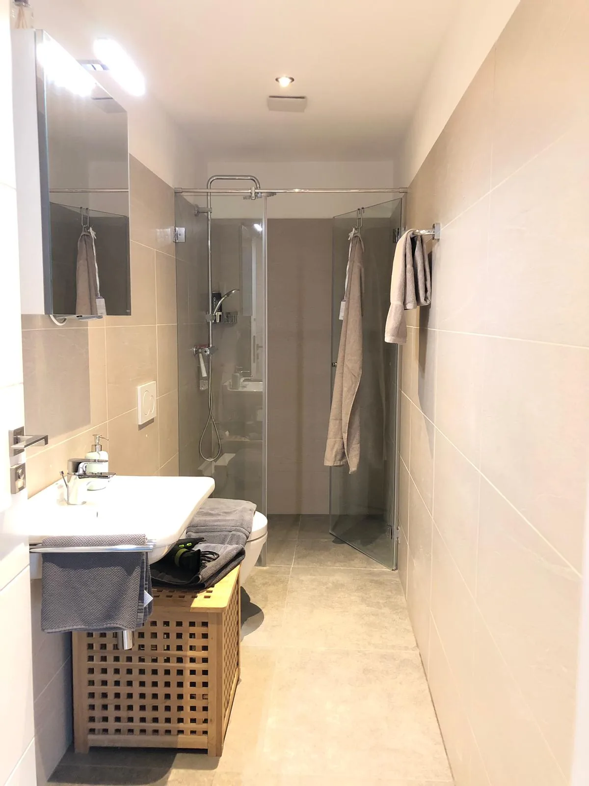 Badezimmer mit ebenerdiger Dusche und Waschtisch im Deluxe Apartment Zwei